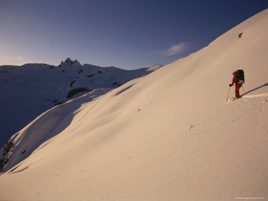 A Man Backcountry Skiing in Evening Light