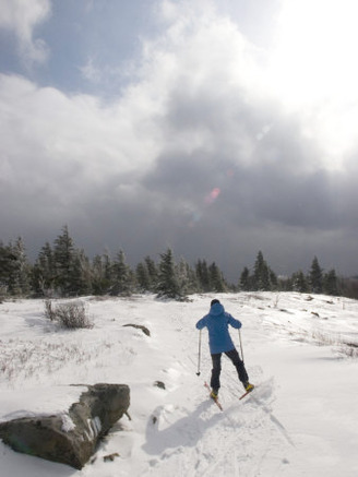 Woman Cross Country Skiing Along a Ridge Trail