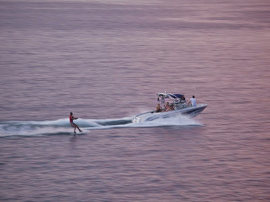 Water-Skiier Skiing Behind a Motorboat at Sunset